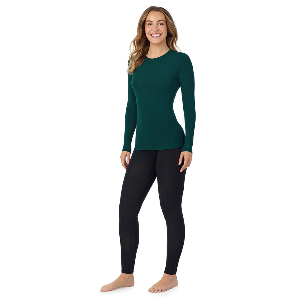 A lady wearing a dark pine long sleeve stretch crew tall.
