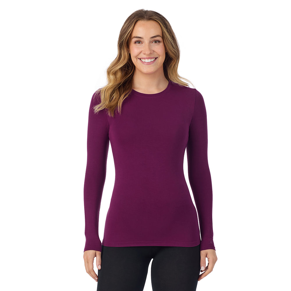 A lady wearing a dark purple long sleeve stretch crew.