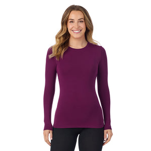 A lady wearing a dark purple long sleeve stretch crew.