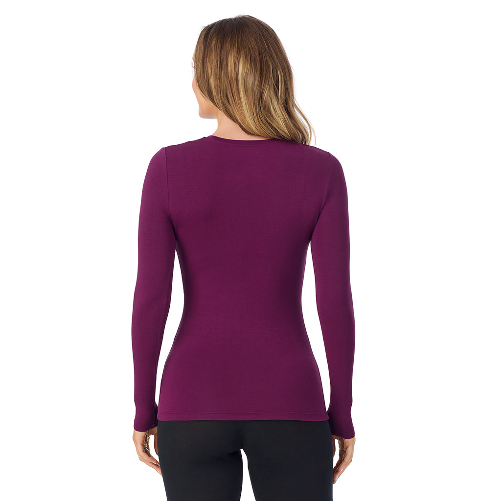 A lady wearing a dark purple long sleeve stretch crew.