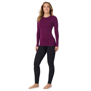 A lady wearing a dark purple long sleeve stretch crew.
