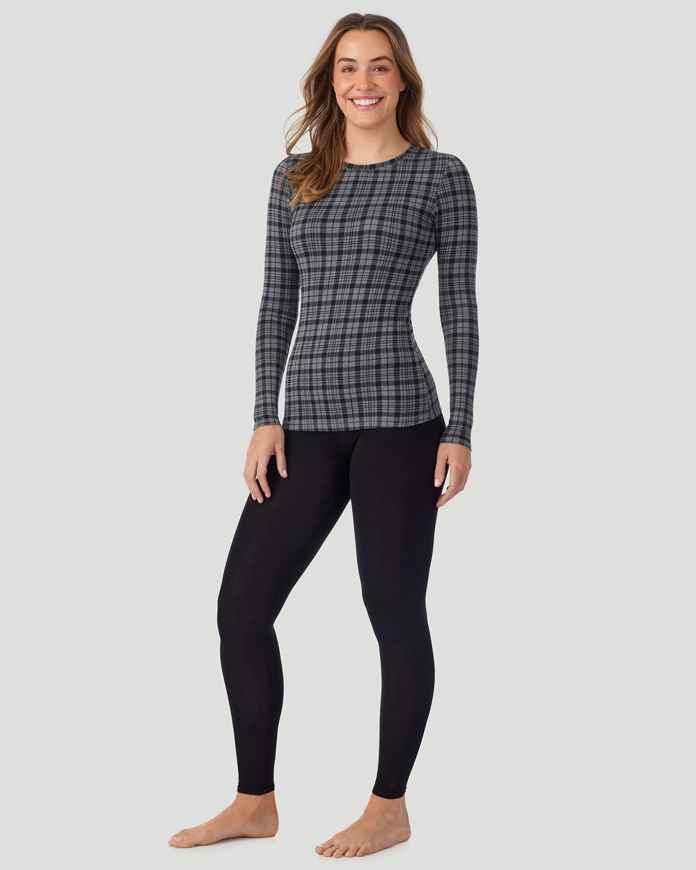 A lady wearing a Charcoal Tartan long sleeve stretch crew front standing pose