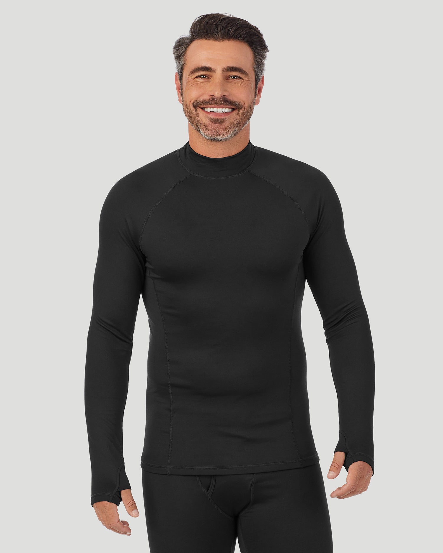 Black;Model is wearing size M. He is 6'2", Waist 32", Inseam 34".@A man wearing black ArctiCore Long Sleeve Mock Neck