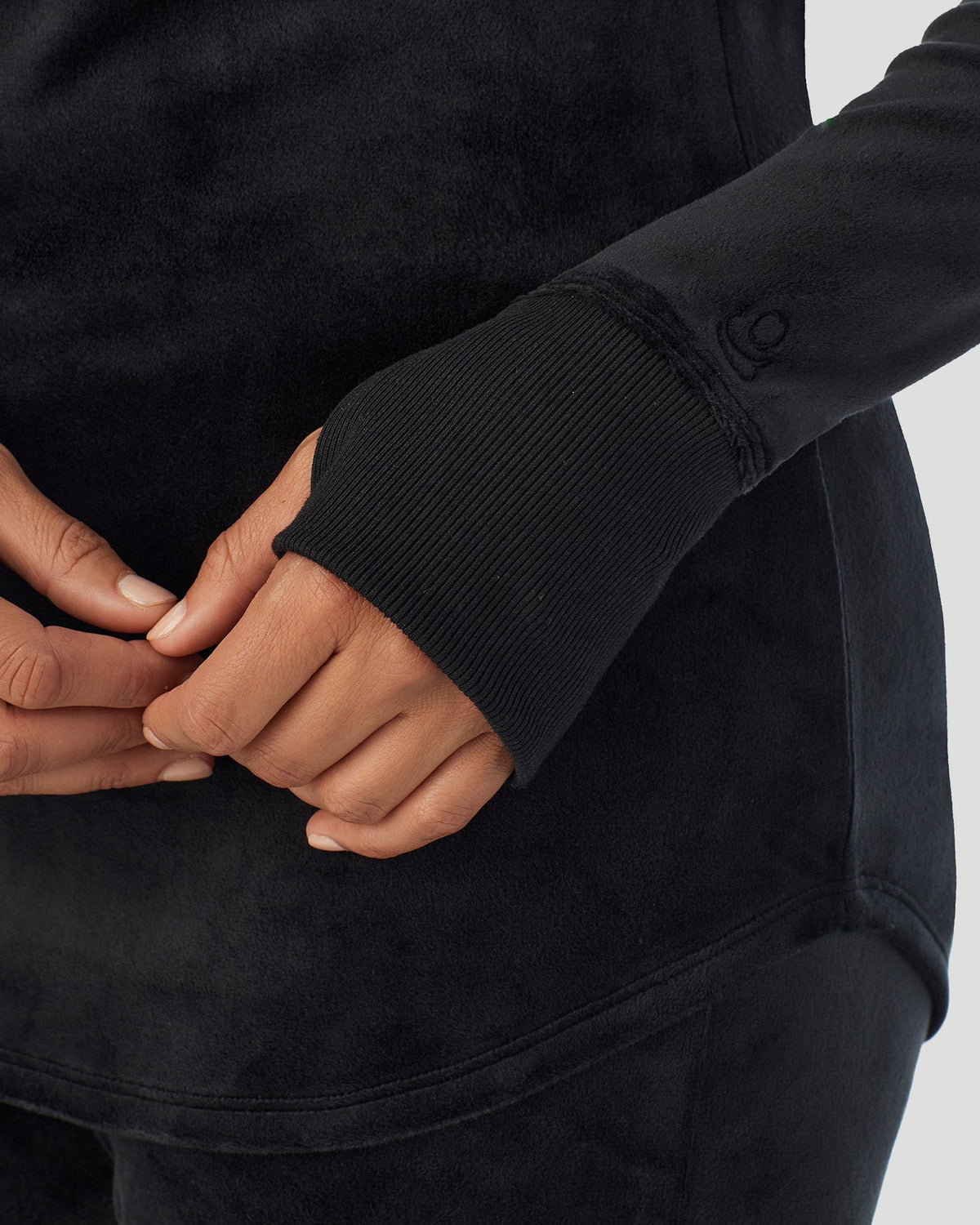 A lady wearing Stretch Velour Long Sleeve V-Neck in black shown in a front view close up detail of the sleeve thumbhole 
