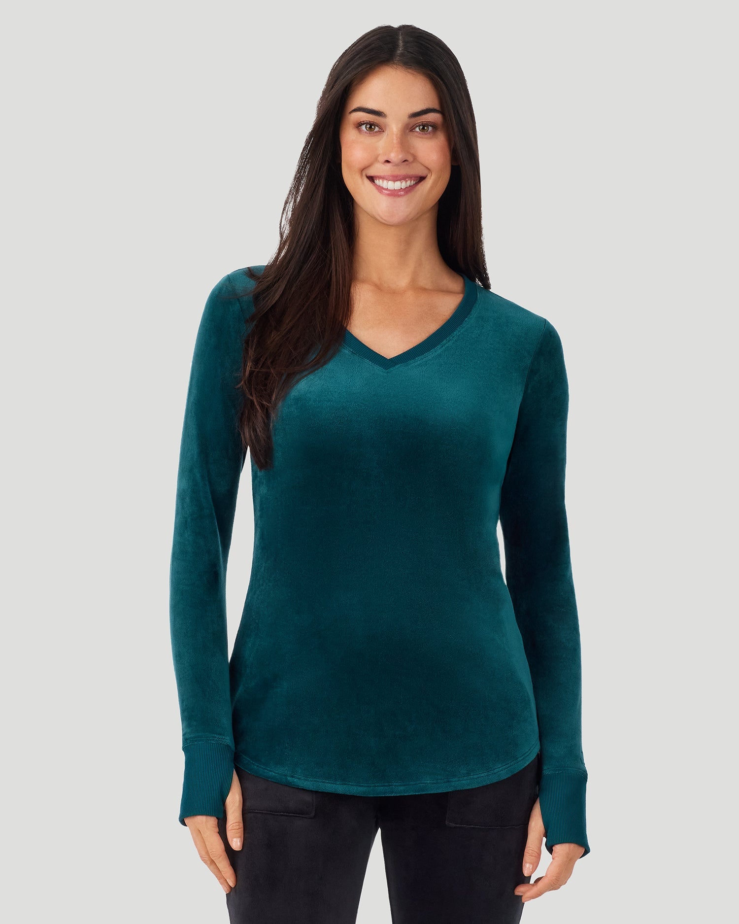 A lady wearing Stretch Velour Long Sleeve V-Neck in deep emerald shown in a front view pose