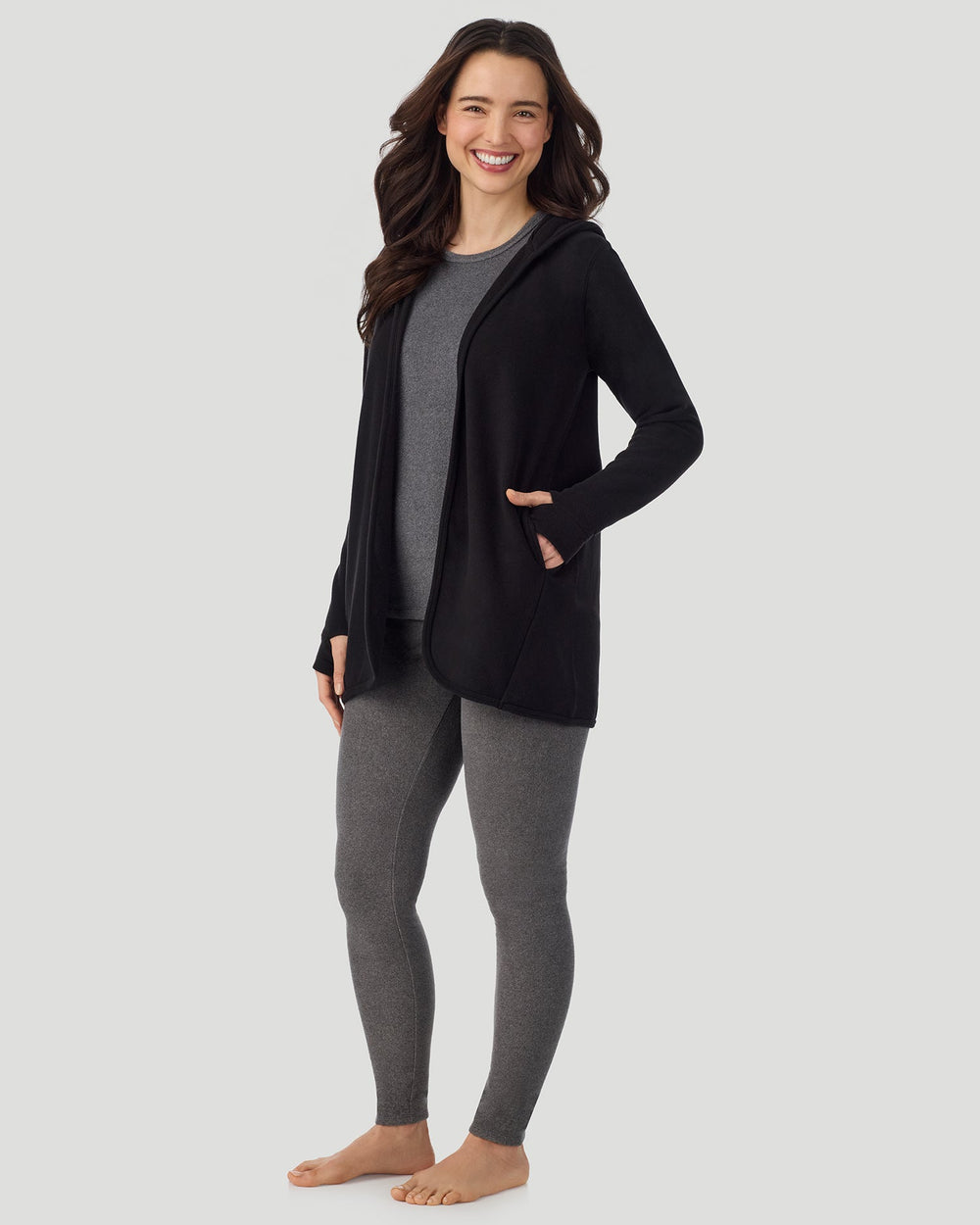 A lady wearing Fleecewear with Stretch Long Sleeve Wrap With Hood black in a standing pose