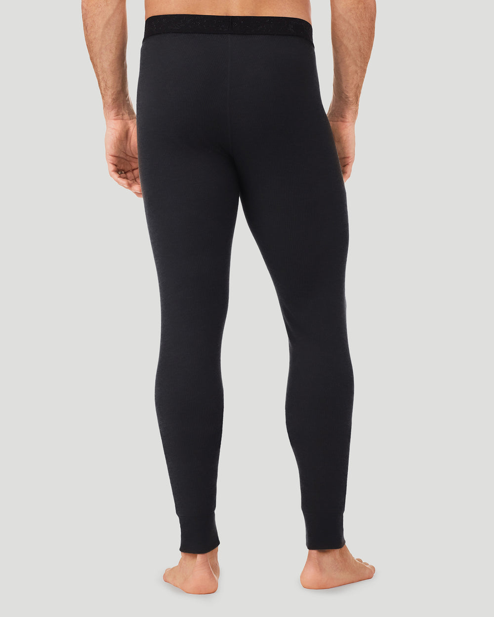 A man wearing a black waffle thermal pant back view