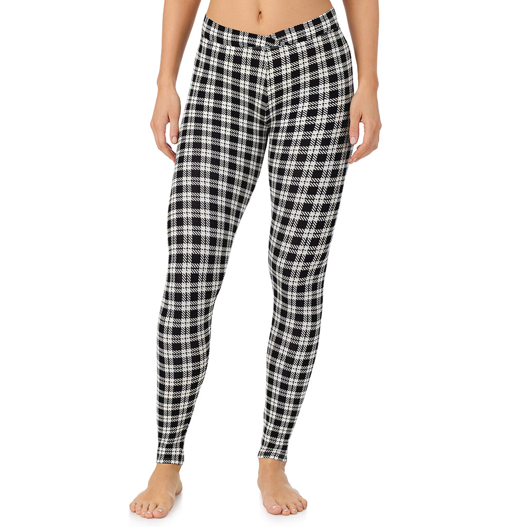 A lady wearing a ivory/black plaid stretch legging.