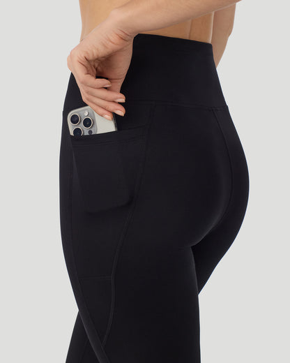 A lady wearing Thermawear Hi-Waisted Legging With Pockets in black shown in a side angle detail close up view