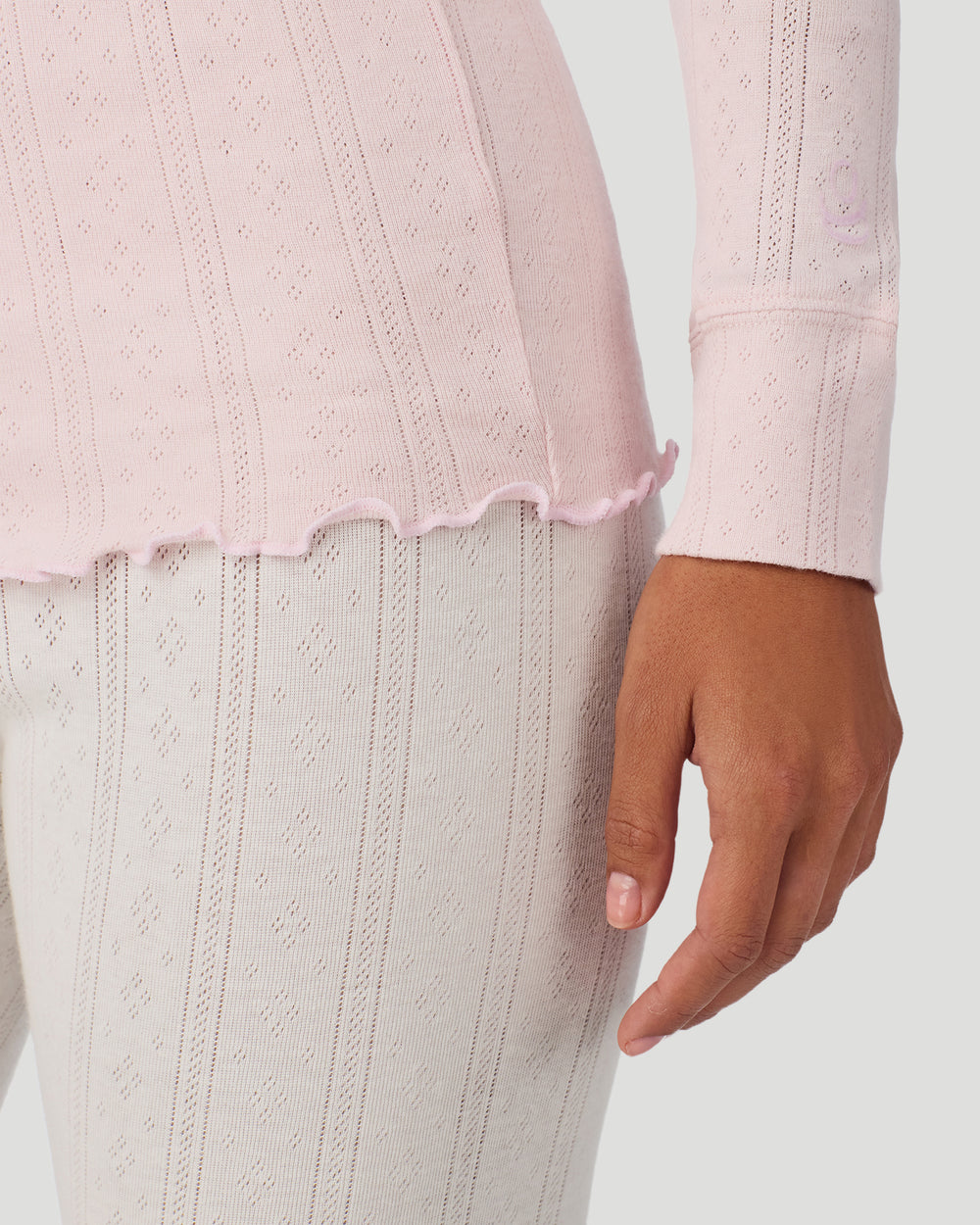 A lady is wearing Pretty Rose Cotton Pointelle Long Sleeve Henley in a front view close up look of the sleeve