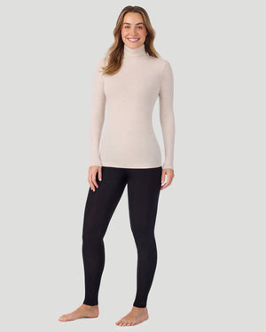 A lady wearing Oatmeal Heather Softwear With Stretch Long Sleeve Turtleneck top in a front standing pose