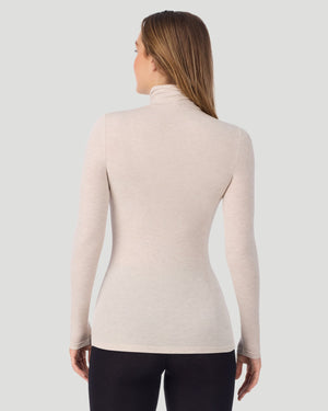 A lady wearing Oatmeal Heather Softwear With Stretch Long Sleeve Turtleneck top in a back pose