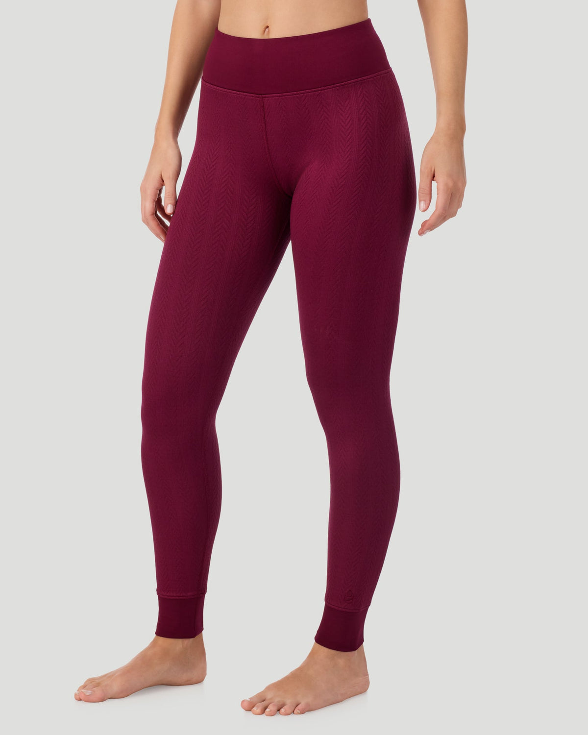 Bordeaux; Model is wearing a size S. She is 5’11.5”, Bust 34”, Waist 27”, Hips 38.5”. @ A lady wearing Cozy Cable Legging in bordeaux posing front view side angled pose