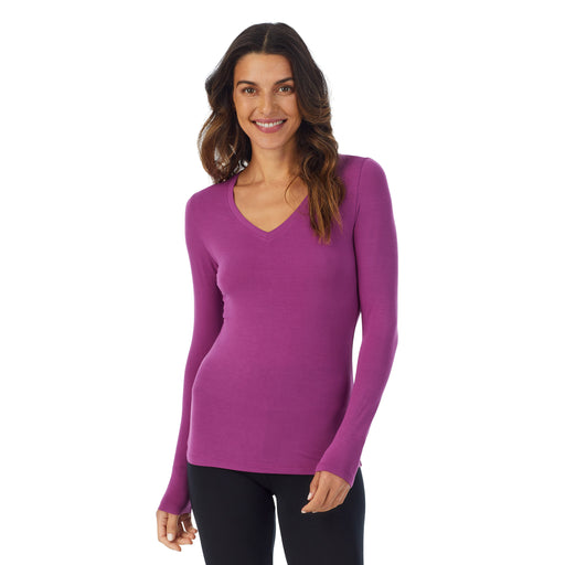 Purple Radiance; Model is wearing size S. She is 5’9”, Bust 34”, Waist 25.5”, Hips 36.5”.@A lady wearing purple radiance long sleeve v-neck softwer with stretch top.