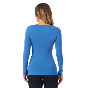 A lady wearing blue comet long sleeve  softwear with stretch v-neck.