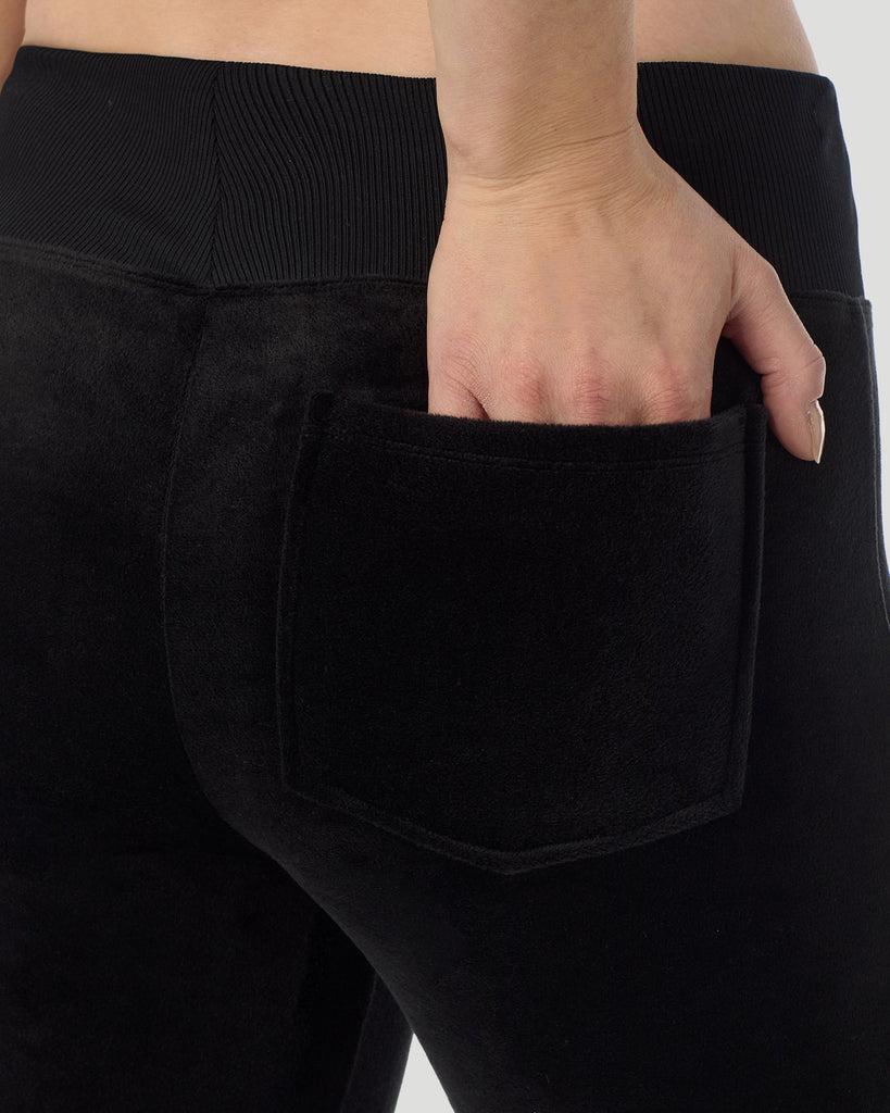 A lady wearing Stretch Velour Boot Cut Legging With Pockets in black shown in a back view close up detail pose