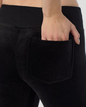 A lady wearing Stretch Velour Boot Cut Legging With Pockets in black shown in a back view close up detail pose
