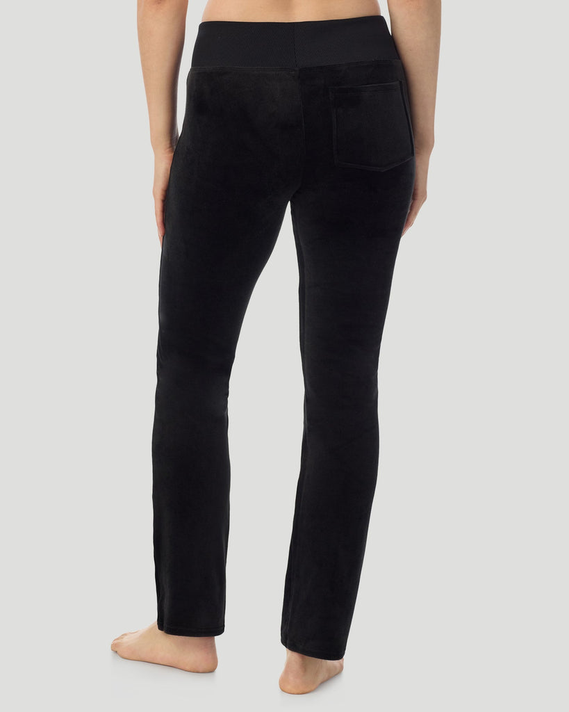 A lady wearing Stretch Velour Boot Cut Legging With Pockets in black shown in a back view pose