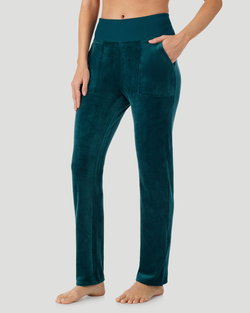 A lady wearing Stretch Velour Boot Cut Legging With Pockets in deep emerald shown in a front view side angle pose