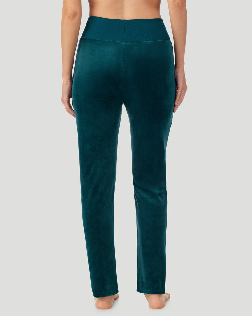 A lady wearing Stretch Velour Boot Cut Legging With Pockets in deep emerald shown in a back view pose