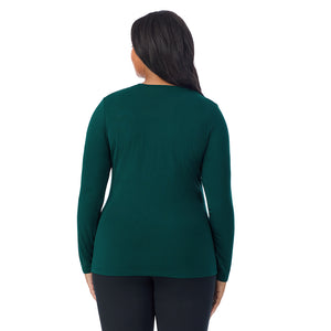 A lady wearing a dark pine long sleeve crew plus.