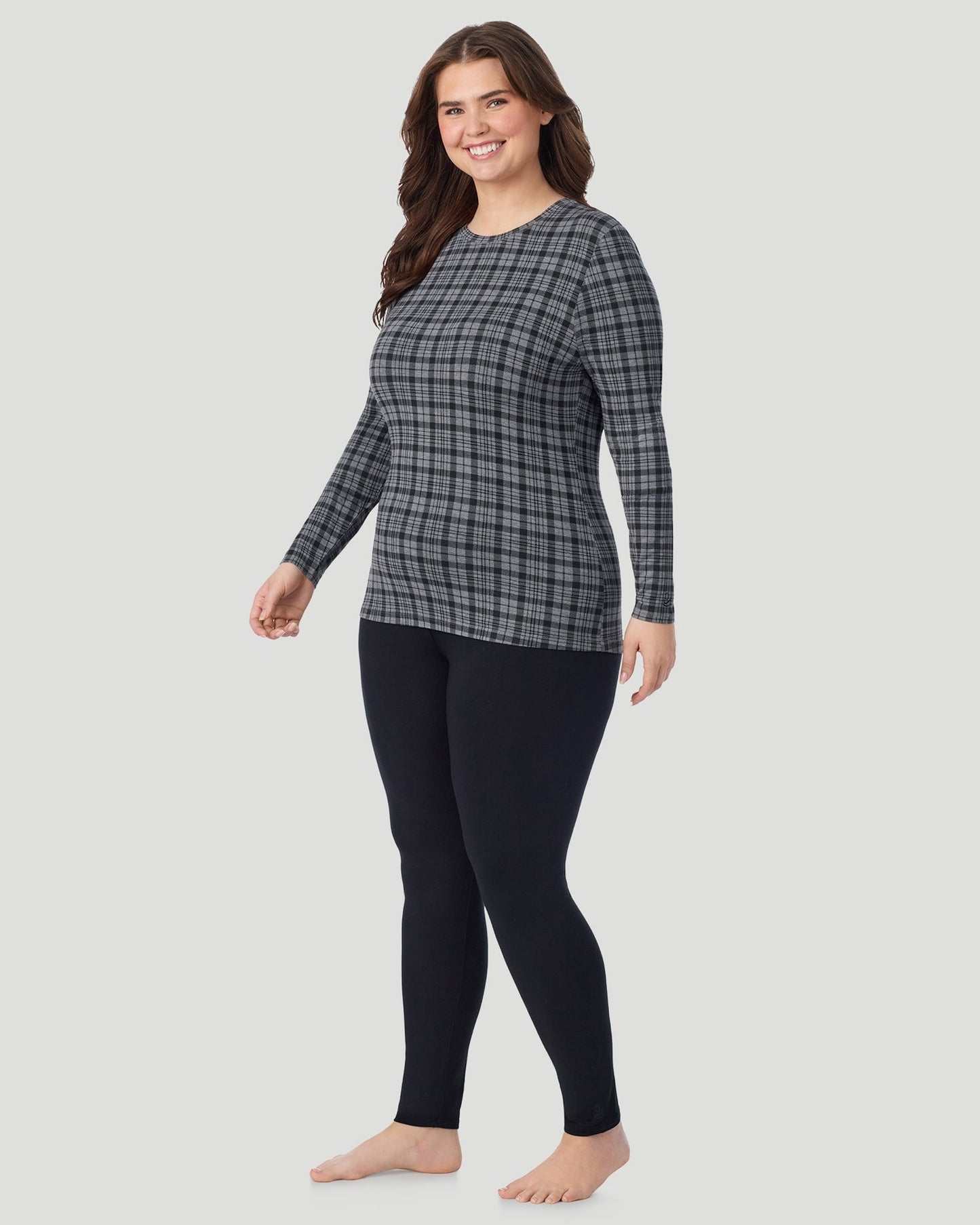 Charcoal Tartan; Model is wearing size 1X. She is 5'10", Bust 44", Waist 36", Hips 49". @ A Plus size lady wearing Charcoal Tartan Softwear With Stretch Long Sleeve Crew PLUS in a front view standing pose