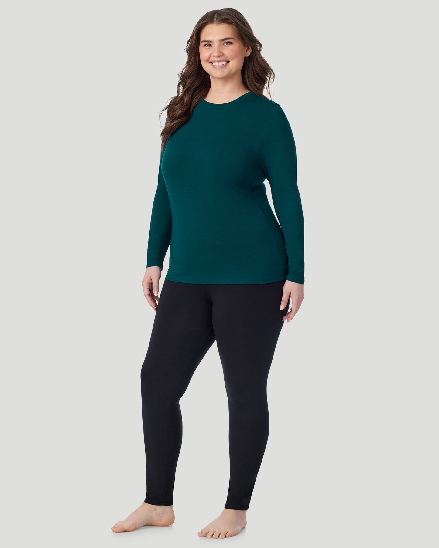 Deep Emerald ; Model is wearing size 1X. She is 5'10", Bust 44", Waist 36", Hips 49". @ A Plus size lady wearing Deep Emerald Softwear With Stretch Long Sleeve Crew PLUS in a front view standing pose