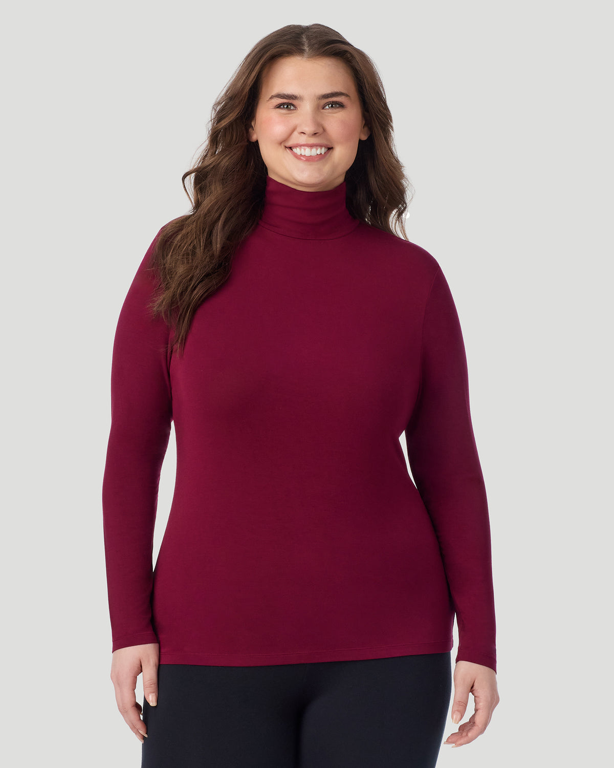 Bordeaux; Model is wearing size 1X. She is 5'10", Bust 44", Waist 36", Hips 49". @ A plus size Lady wearing Bordeaux Softwear With Stretch Long Sleeve Turtleneck PLUS in a front view pose