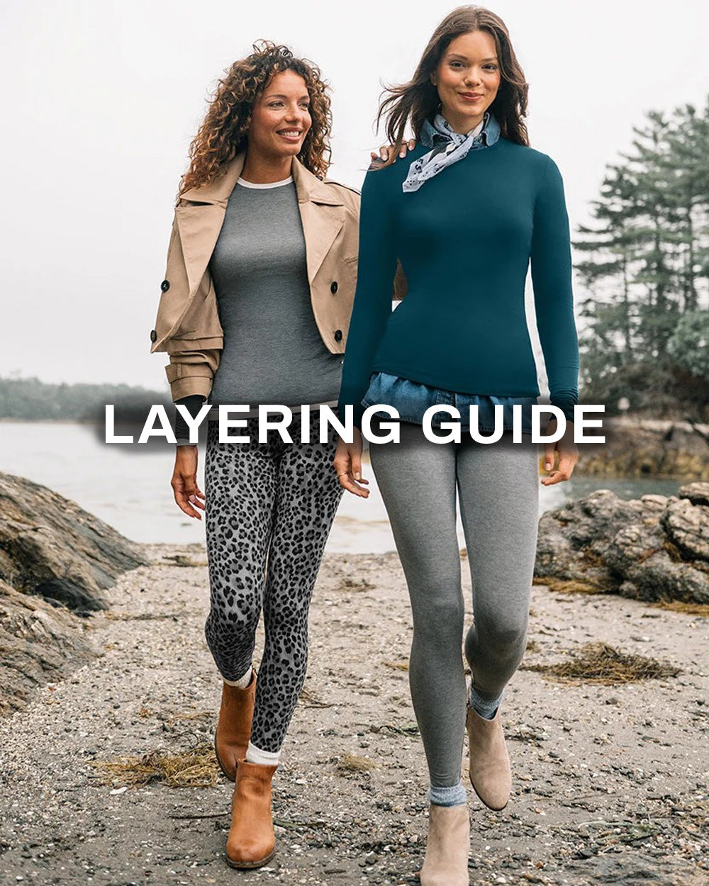 Two women walking outdoors on a rocky shoreline wearing layered outfits, with large overlaid text reading 'LAYERING GUIDE'. Because people and a real outdoor environment are present, this is Lifestyle rather than Product/Packaging.