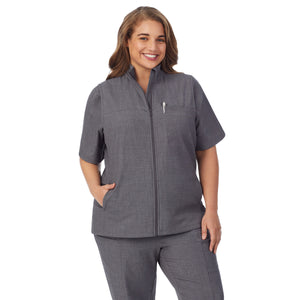 A lady wearing charcoal heather scrub vest plus.