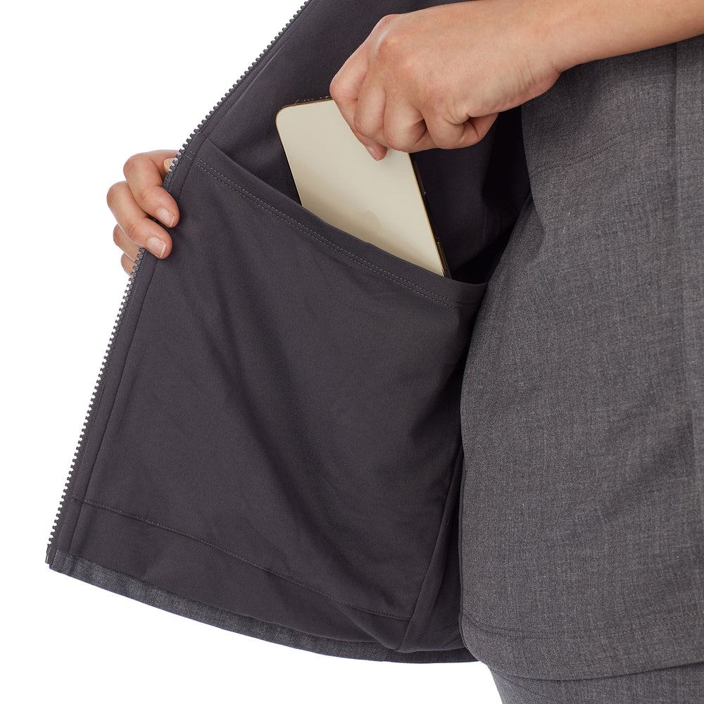 A lady wearing charcoal heather scrub vest plus.