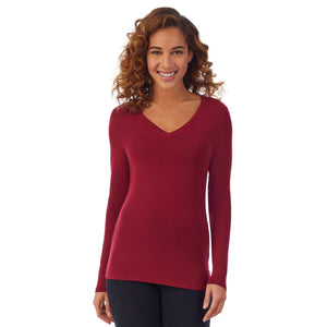 A lady wearing a rhubarb long sleeve stretch V-neck PETITE.
