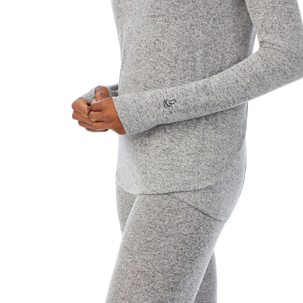 A lady wearing a marled grey long sleeve tunic hoodie.