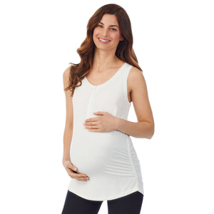 A lady wearing a ivory sleeveless maternity snap front henley tank top. #Model is wearing a maternity bump.
