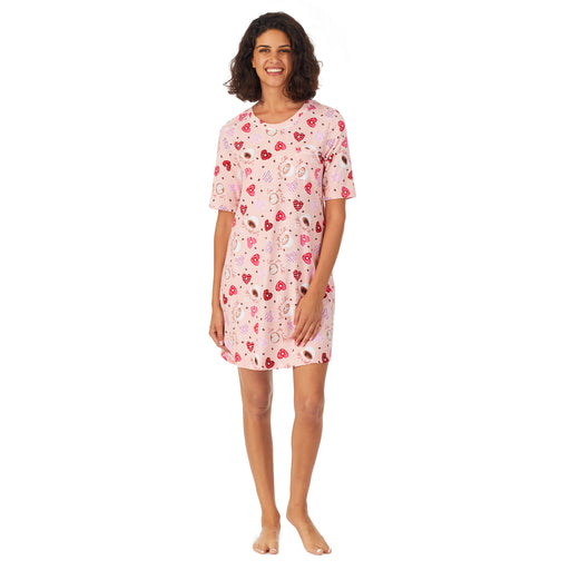A lady wearing elbow sleeve pink sleep shirt with heart shaped print