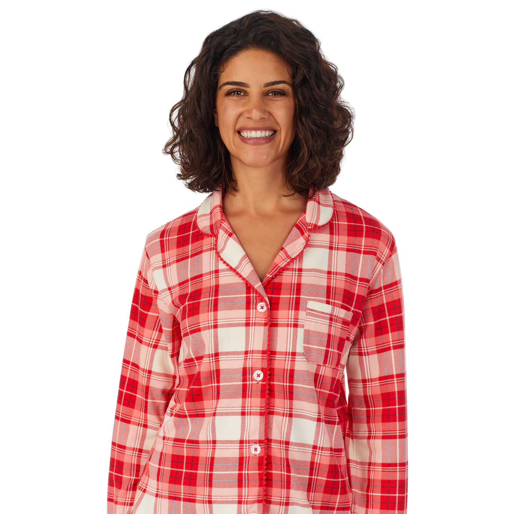 A lady wearing a white long sleeve pajama set with red ivory plaid.
