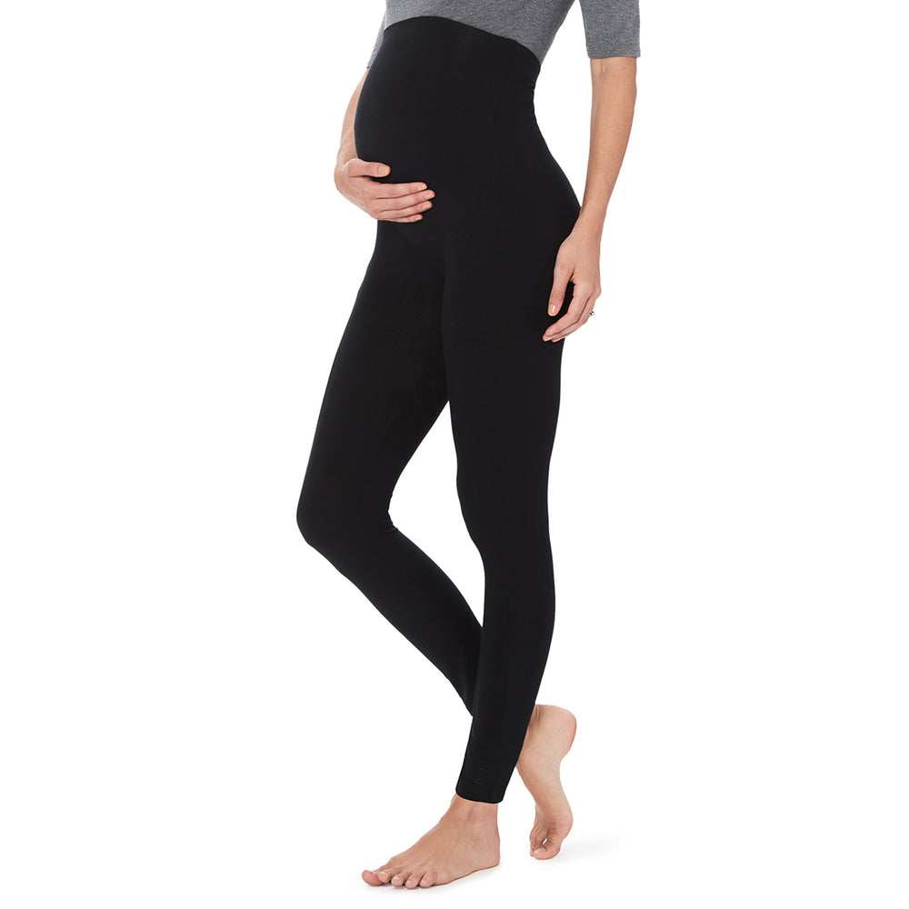A lady wearing a black maternity legging. #Model is wearing a maternity bump.