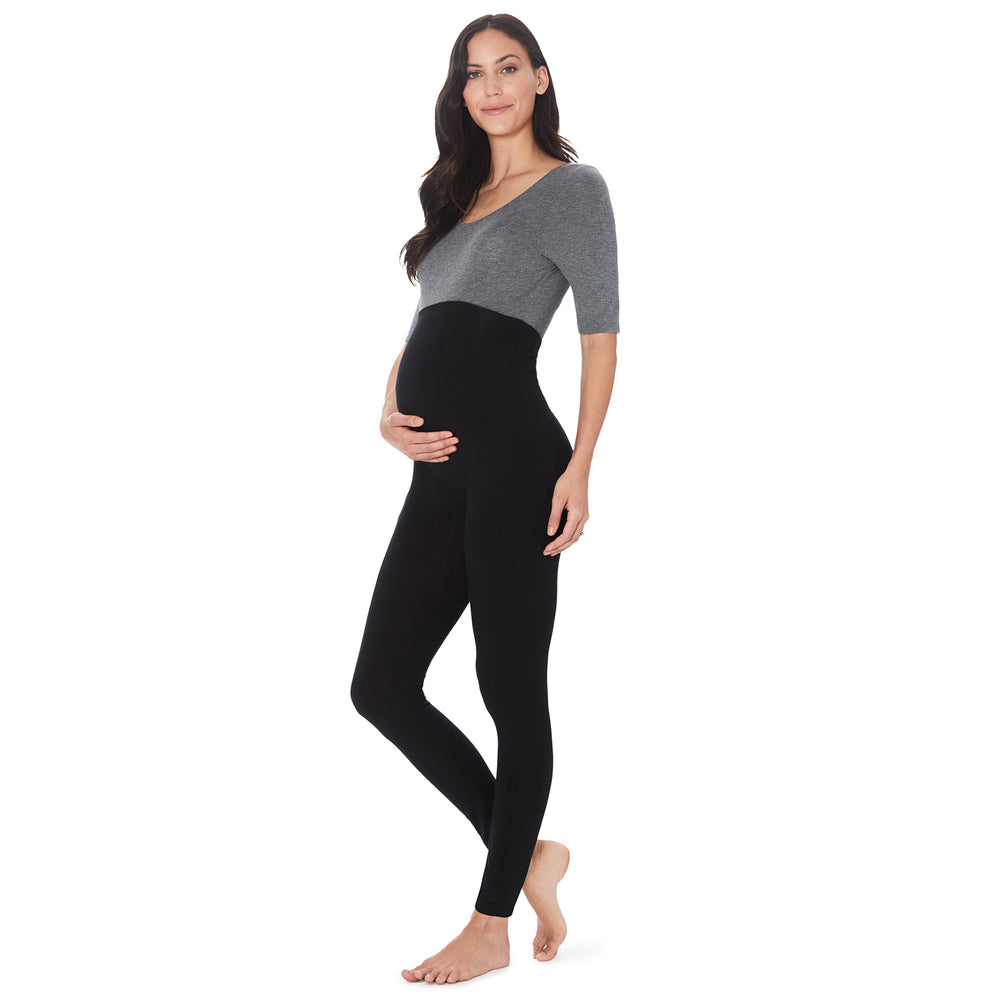A lady wearing a black maternity legging. #Model is wearing a maternity bump.