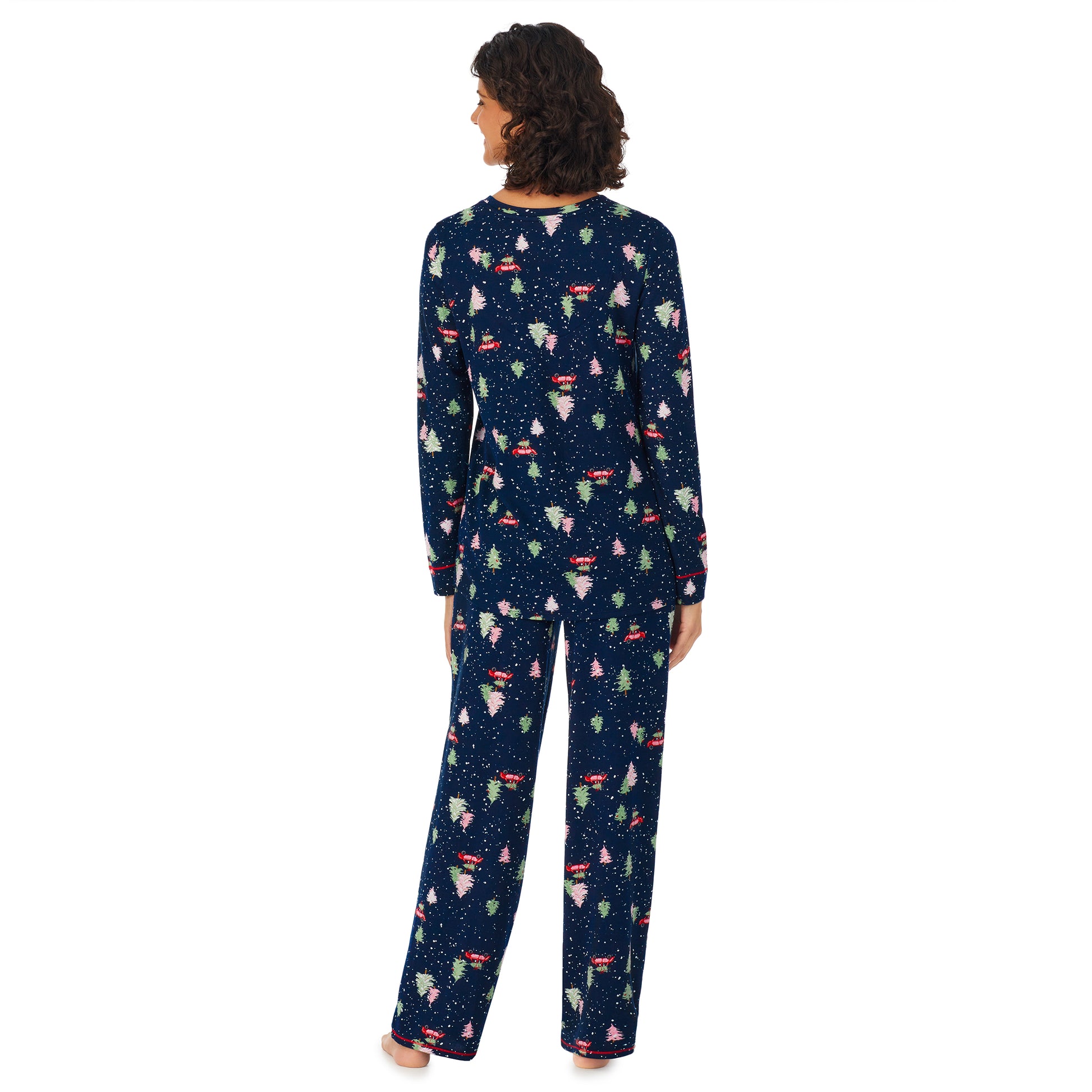 A lady wearing a navy long sleeve pajama set with tree hunting pattern.