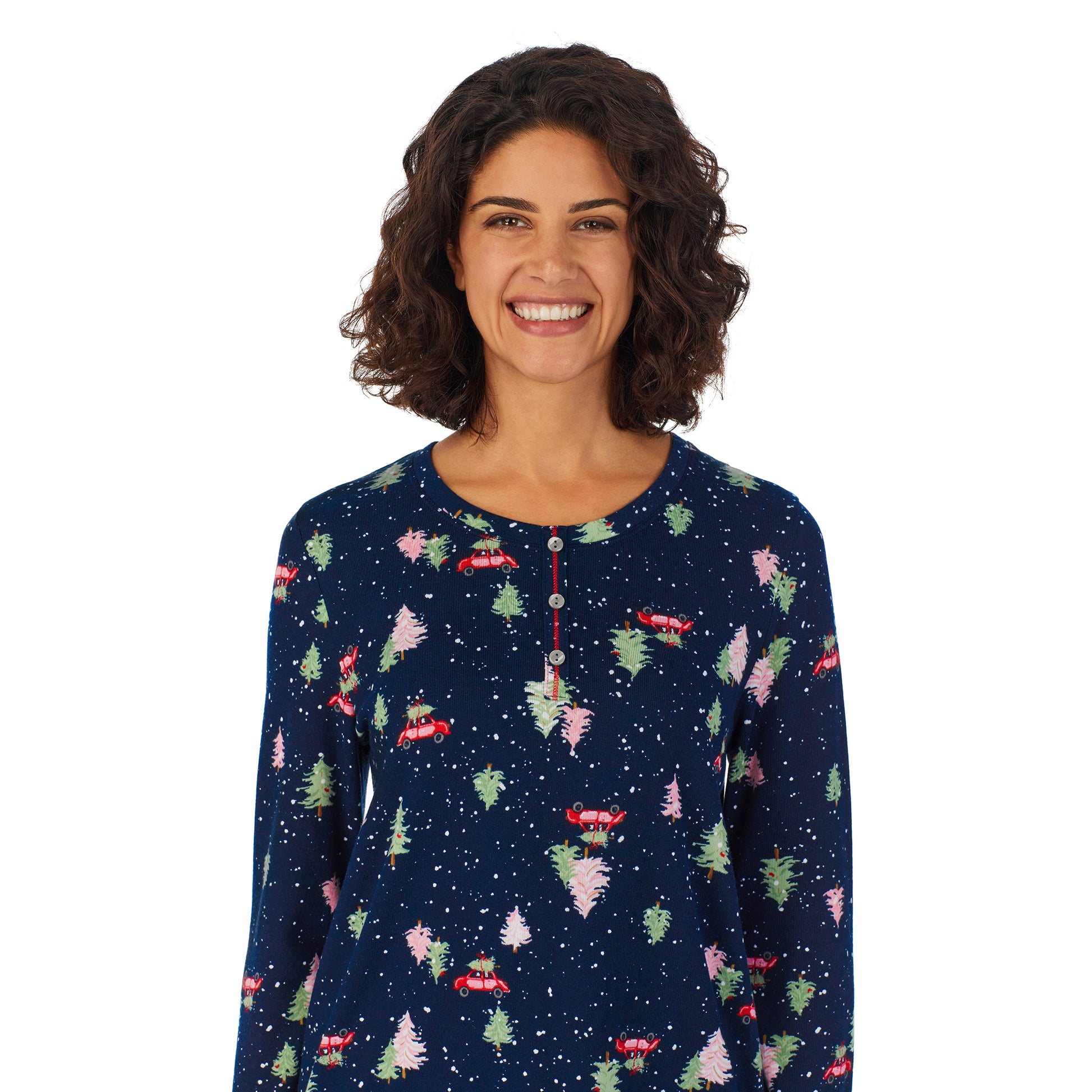 A lady wearing a navy long sleeve pajama set with tree hunting pattern.