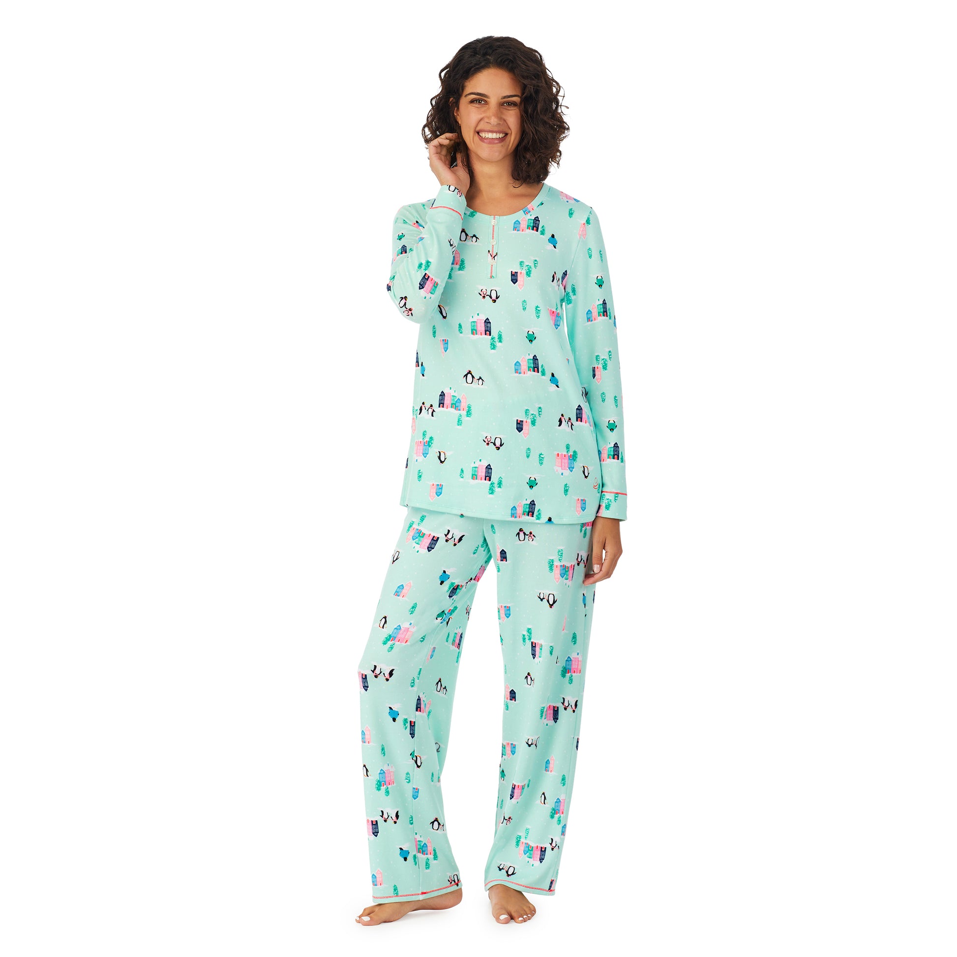 A lady wearing a teal long sleeve pajama set with penguins pattern.