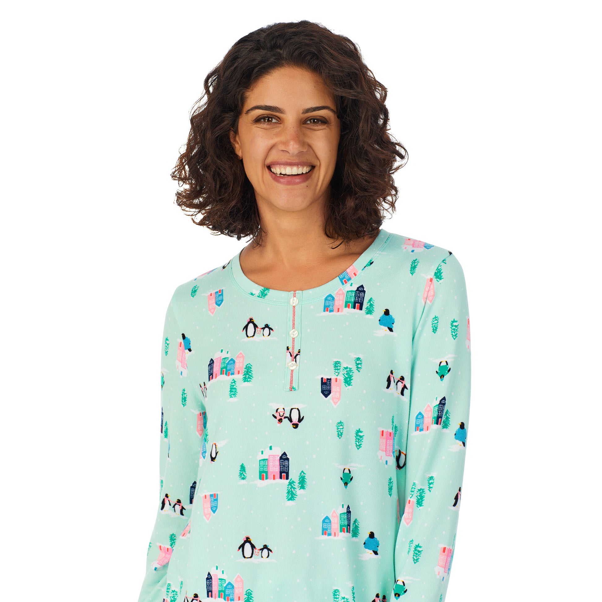 A lady wearing a teal long sleeve pajama set with penguins pattern.