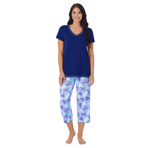 A lady wearing navy short sleeve cotton blen top with butterfly printed cropped pant 2 pc pajama set.