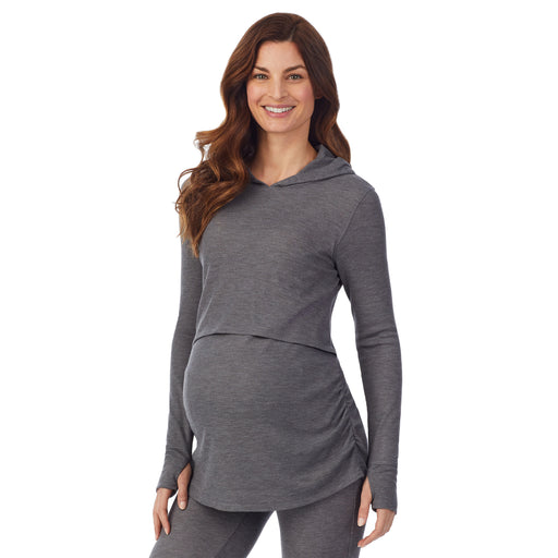 A lady wearing a stone grey heather long sleeve maternity hoodie top. 