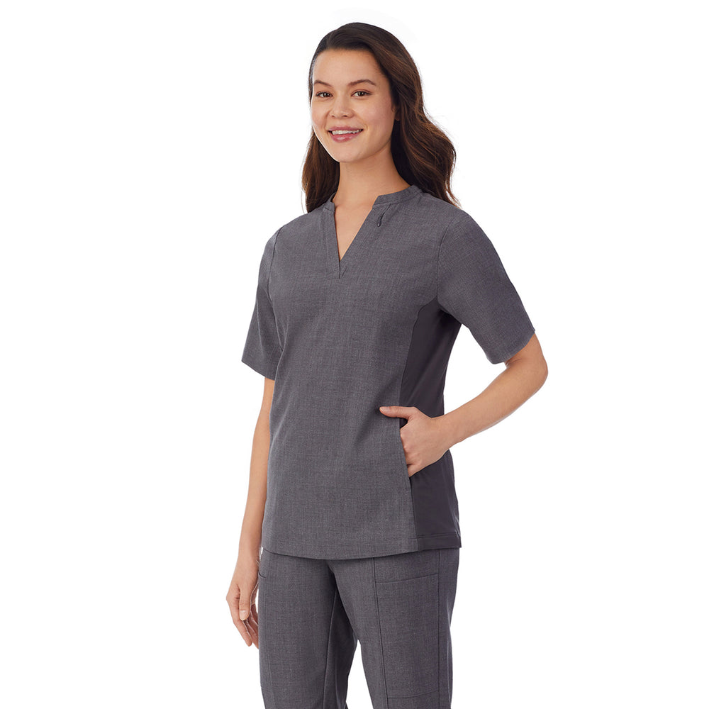 A lady wearing charcoal heather scrub split neck top.