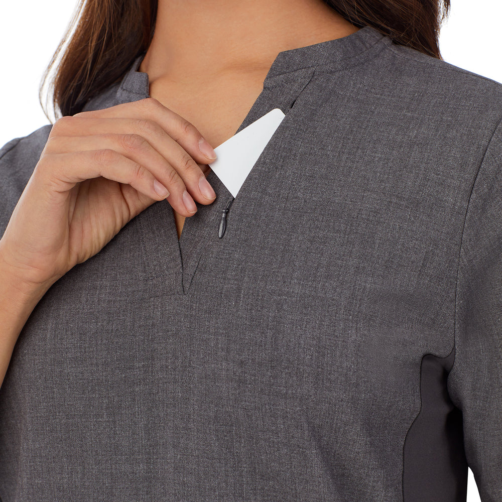 A lady wearing charcoal heather scrub split neck top.