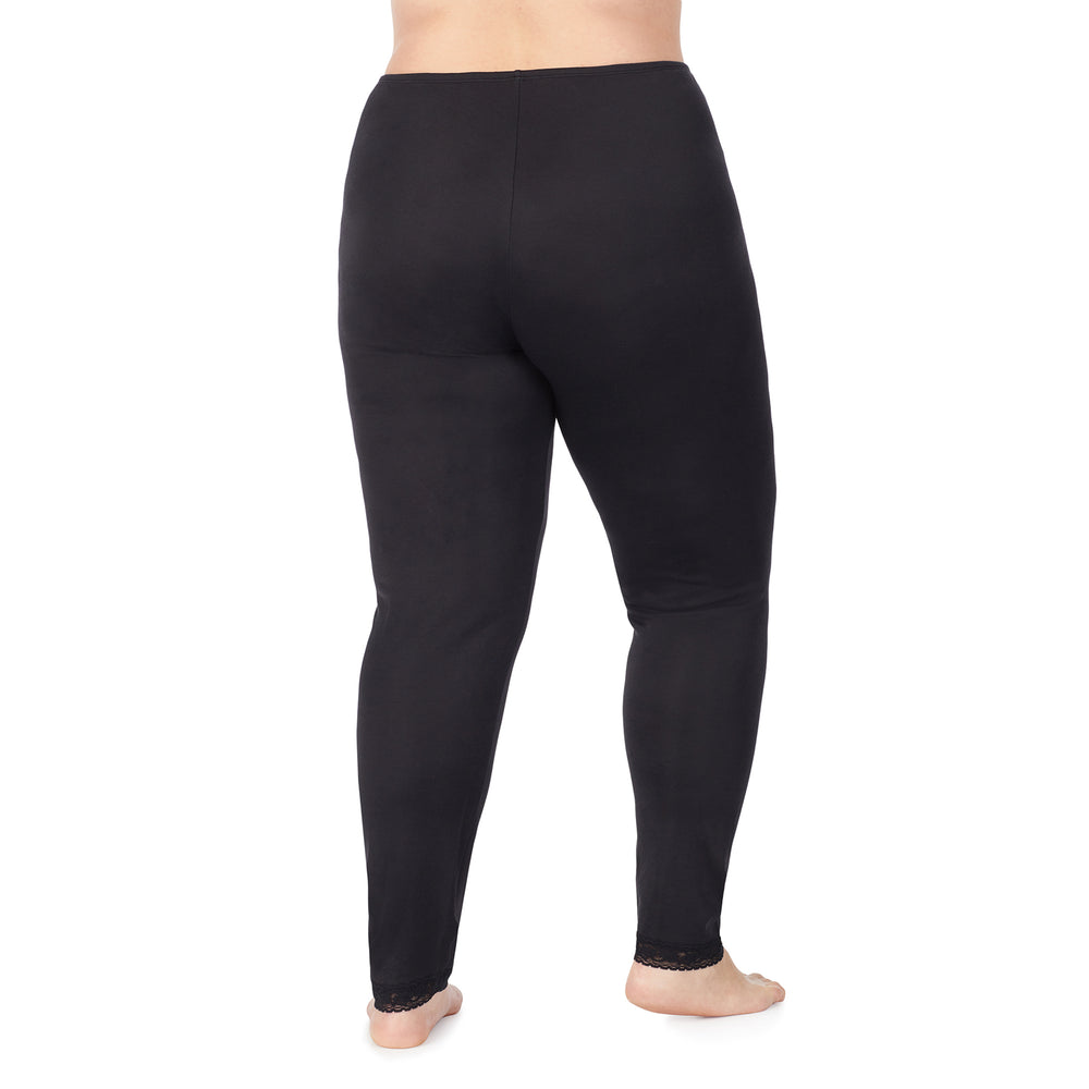 A lady wearing a black lace edge legging plus.