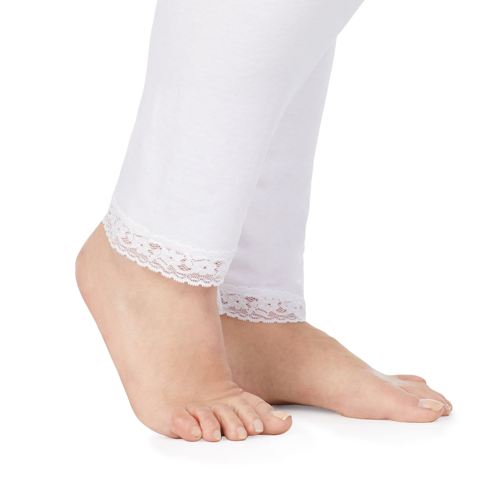 A lady wearing a white lace edge legging plus.