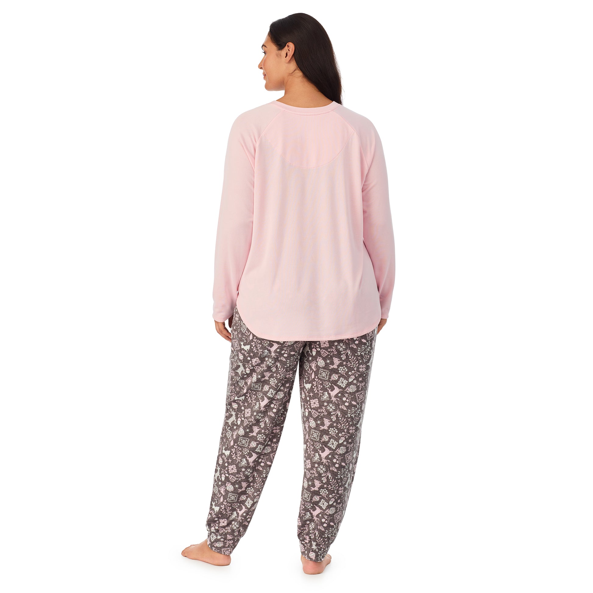 A lady wearing a pink long sleeve top and bottom pajama set with nordic pattern.