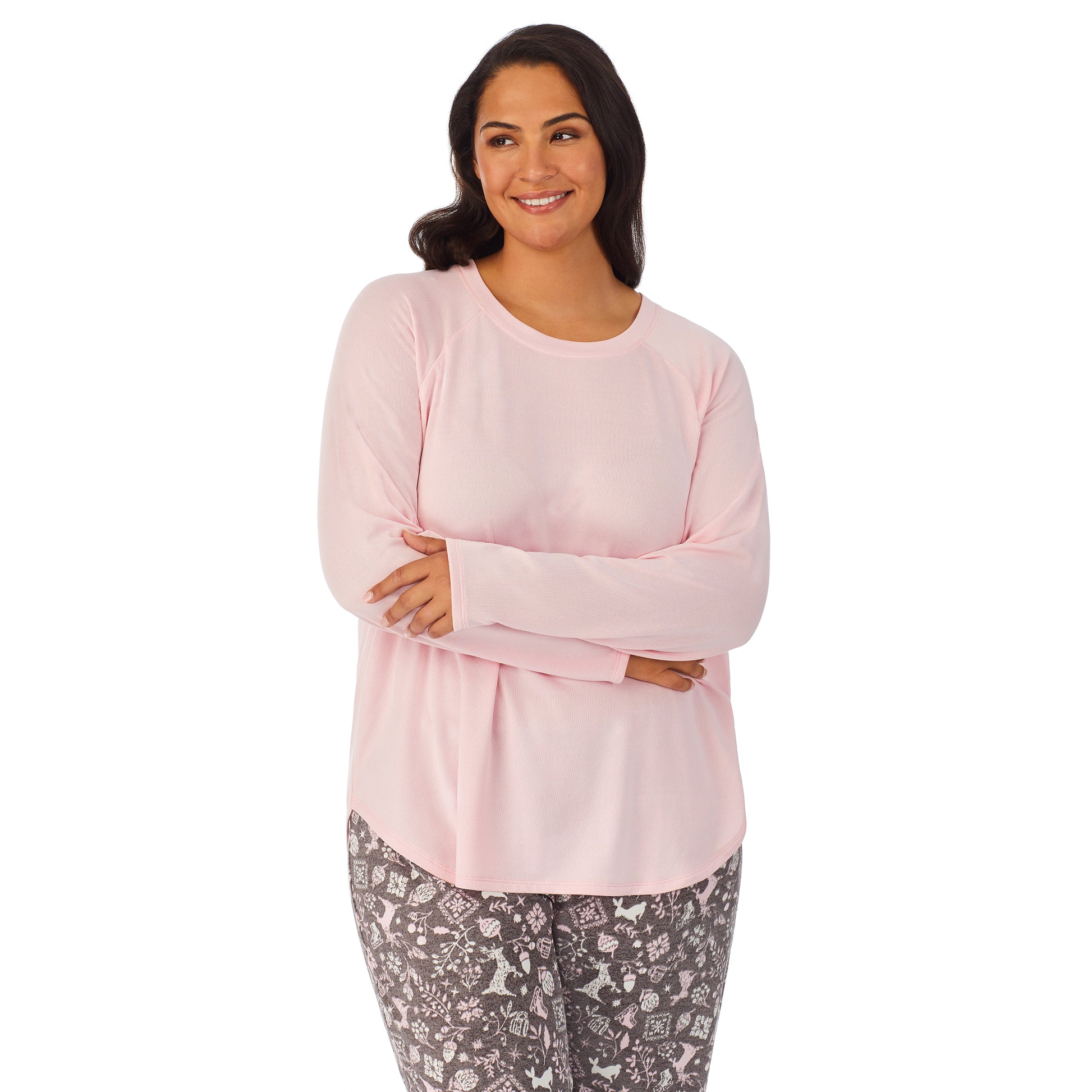 A lady wearing a pink long sleeve top and bottom pajama set with nordic pattern.